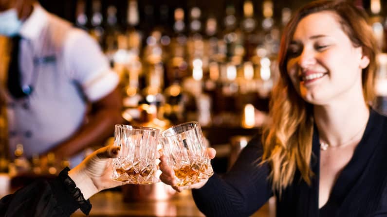 Women clinking whiskey glass